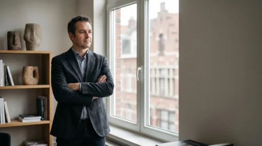 Entrepreneur belge examinant une facture impayee avec determination, symbole des demarches amiables et judiciaires de recouvrement